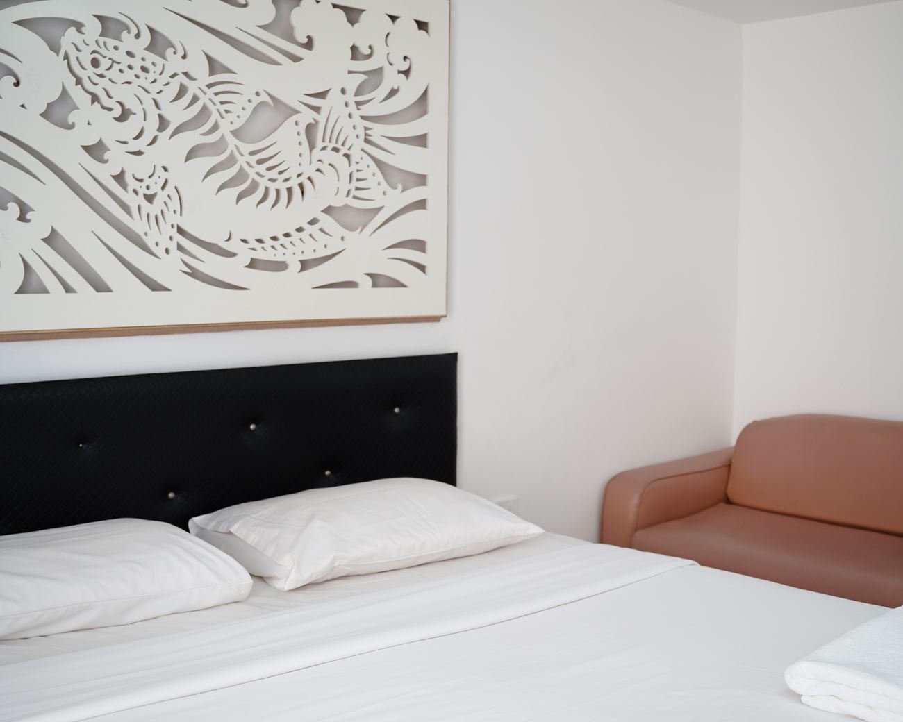 Deluxe room bed with armchair beside it