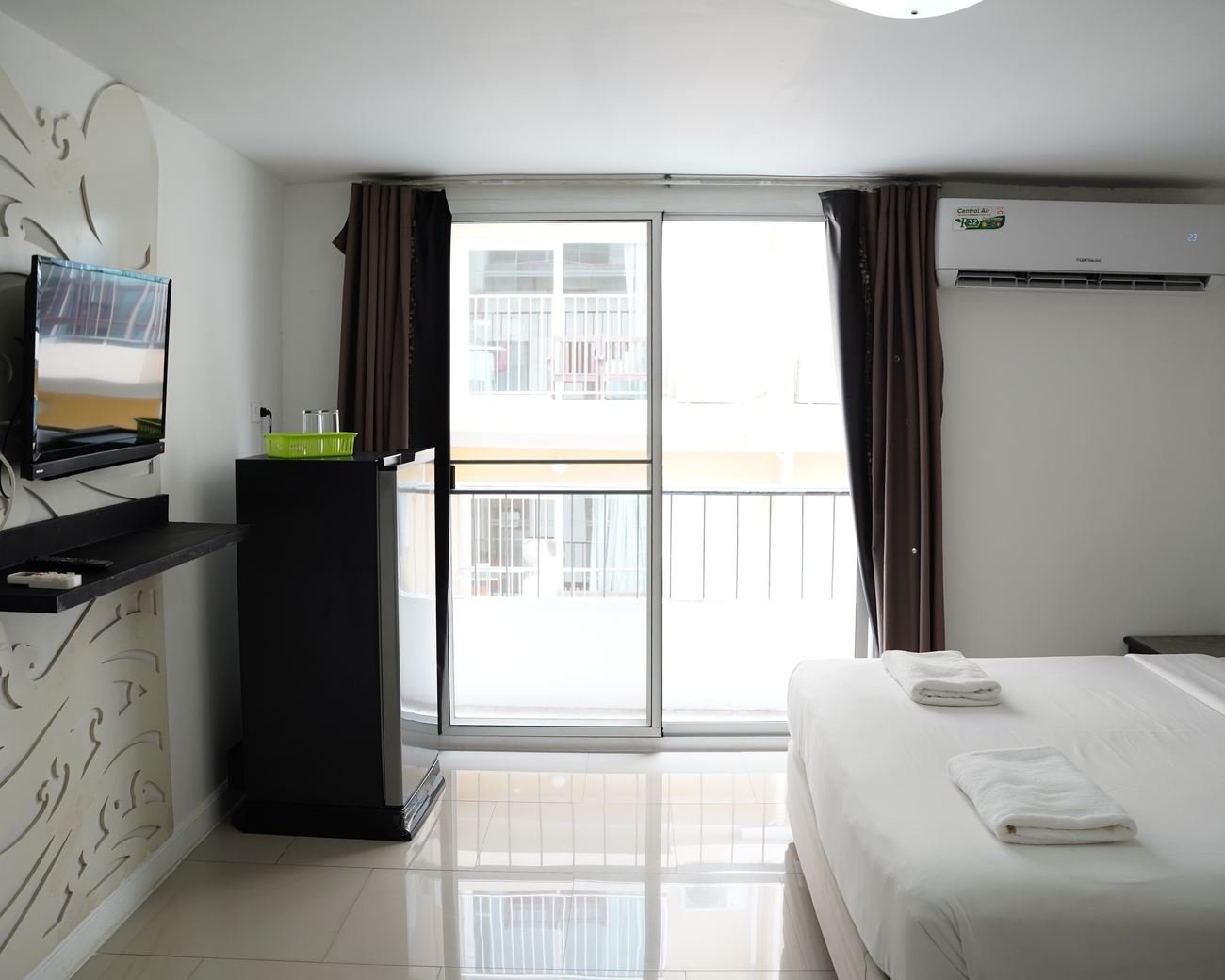 Deluxe room with television, fridge and balcony door