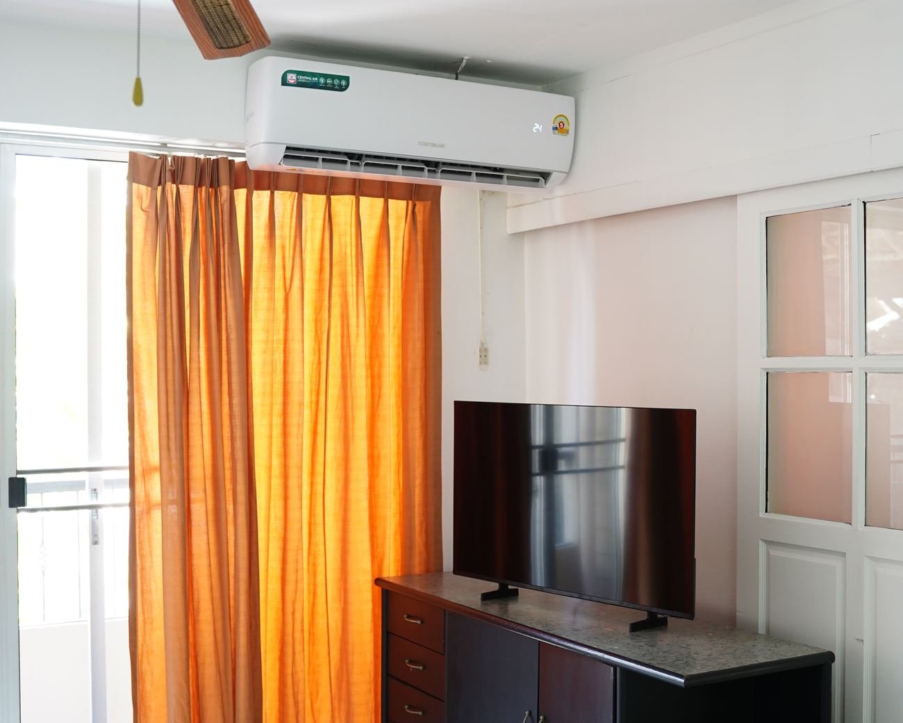 Suite living area with television cabinet and balcony curtains