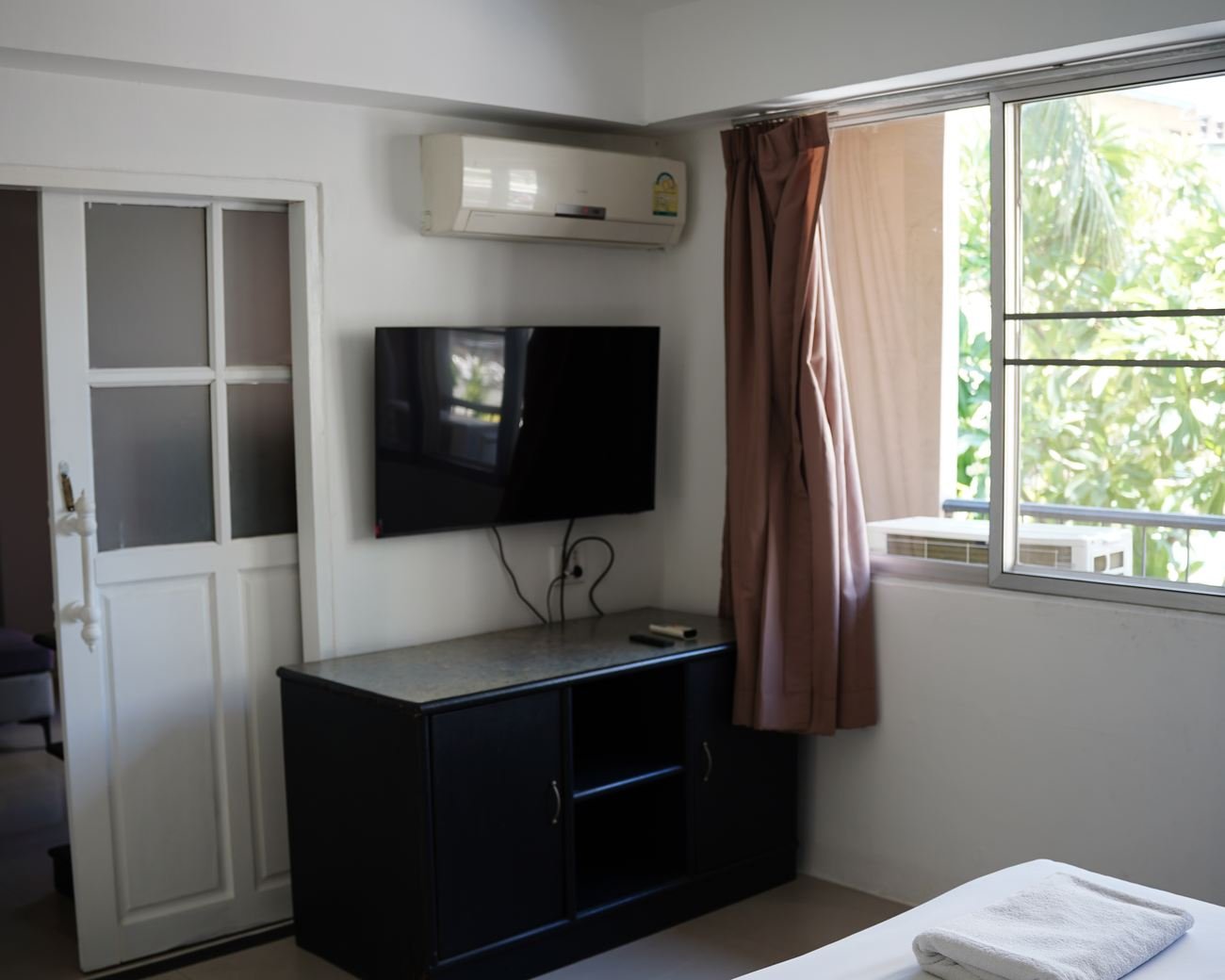 Suite bedroom with television and window